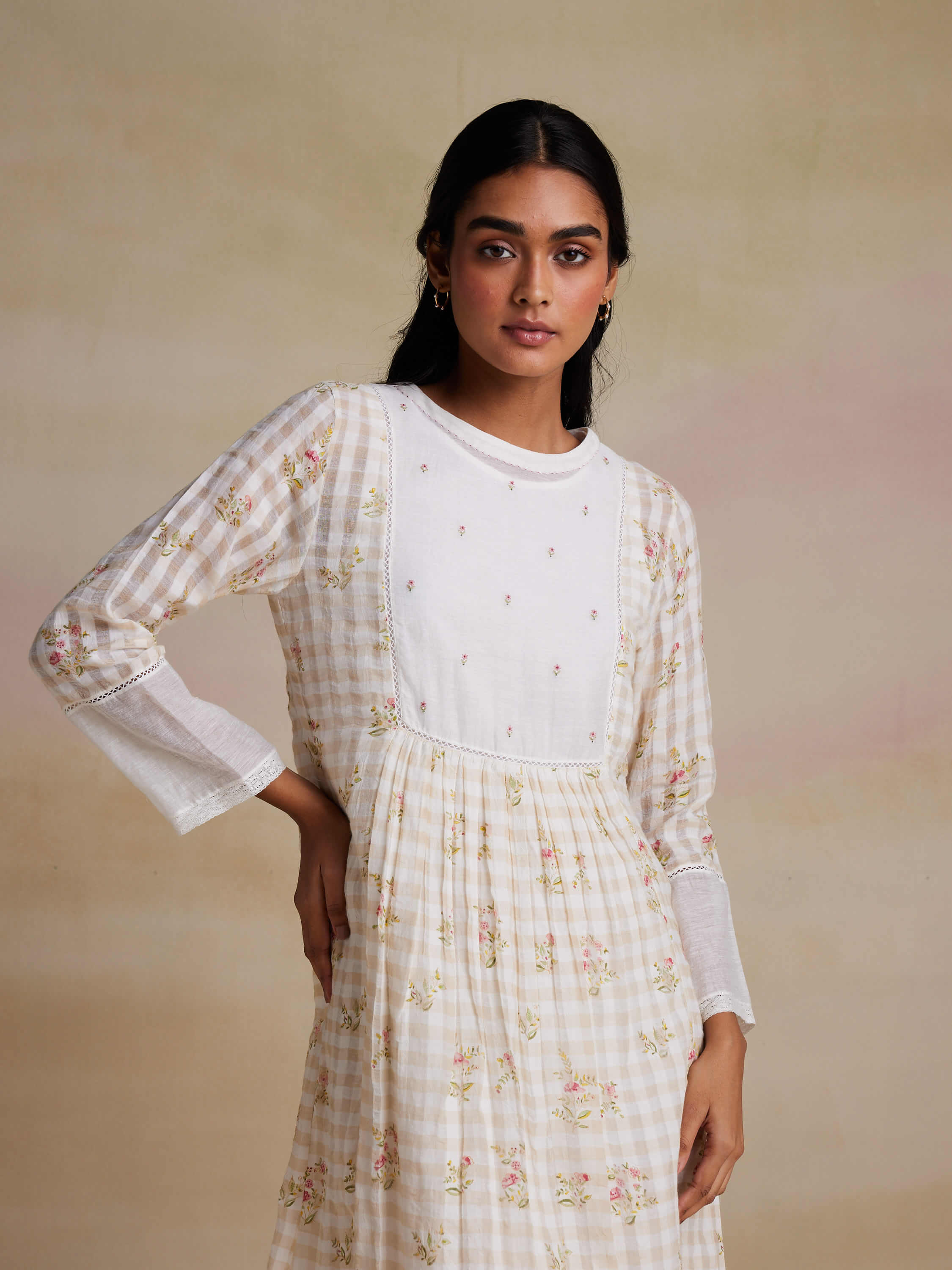 Woman modeling a white floral summer dress with checkered pattern.
