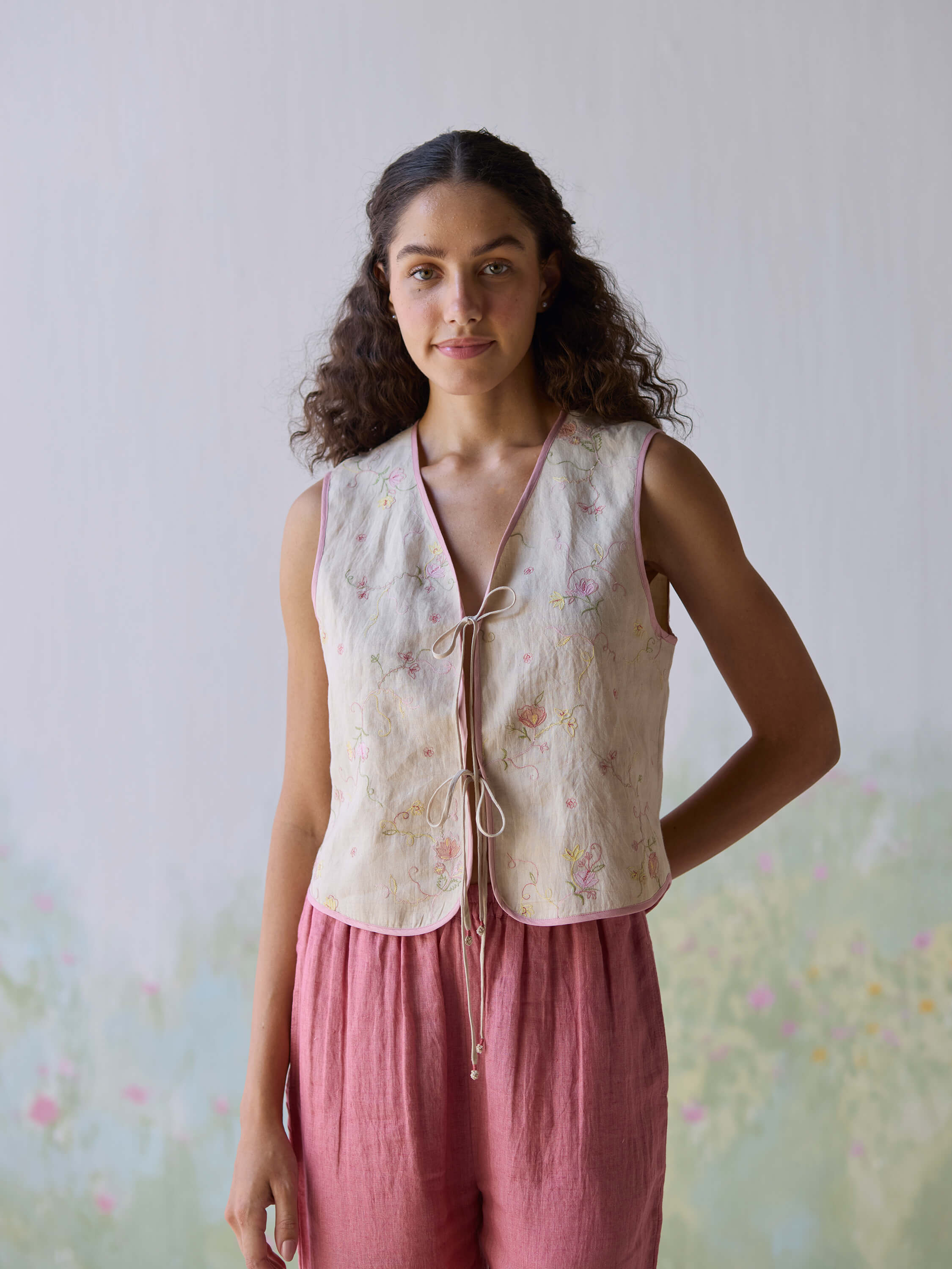 "Fanfare Linen Gilet with delicate floral embroidery and ties."