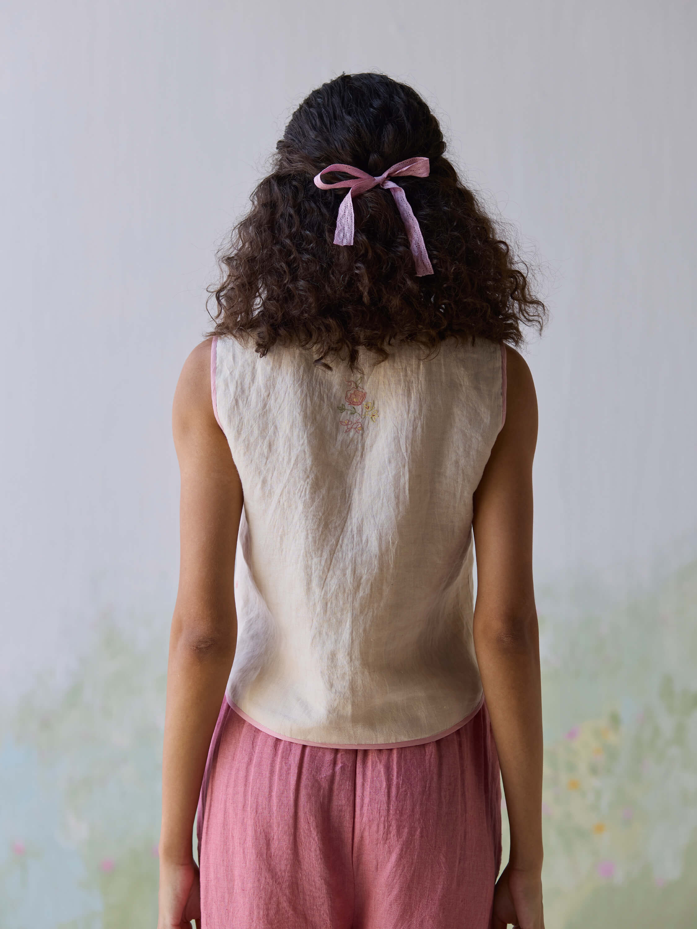 Elegant Fanfare Linen Gilet in natural fabric, styled with pink accents.