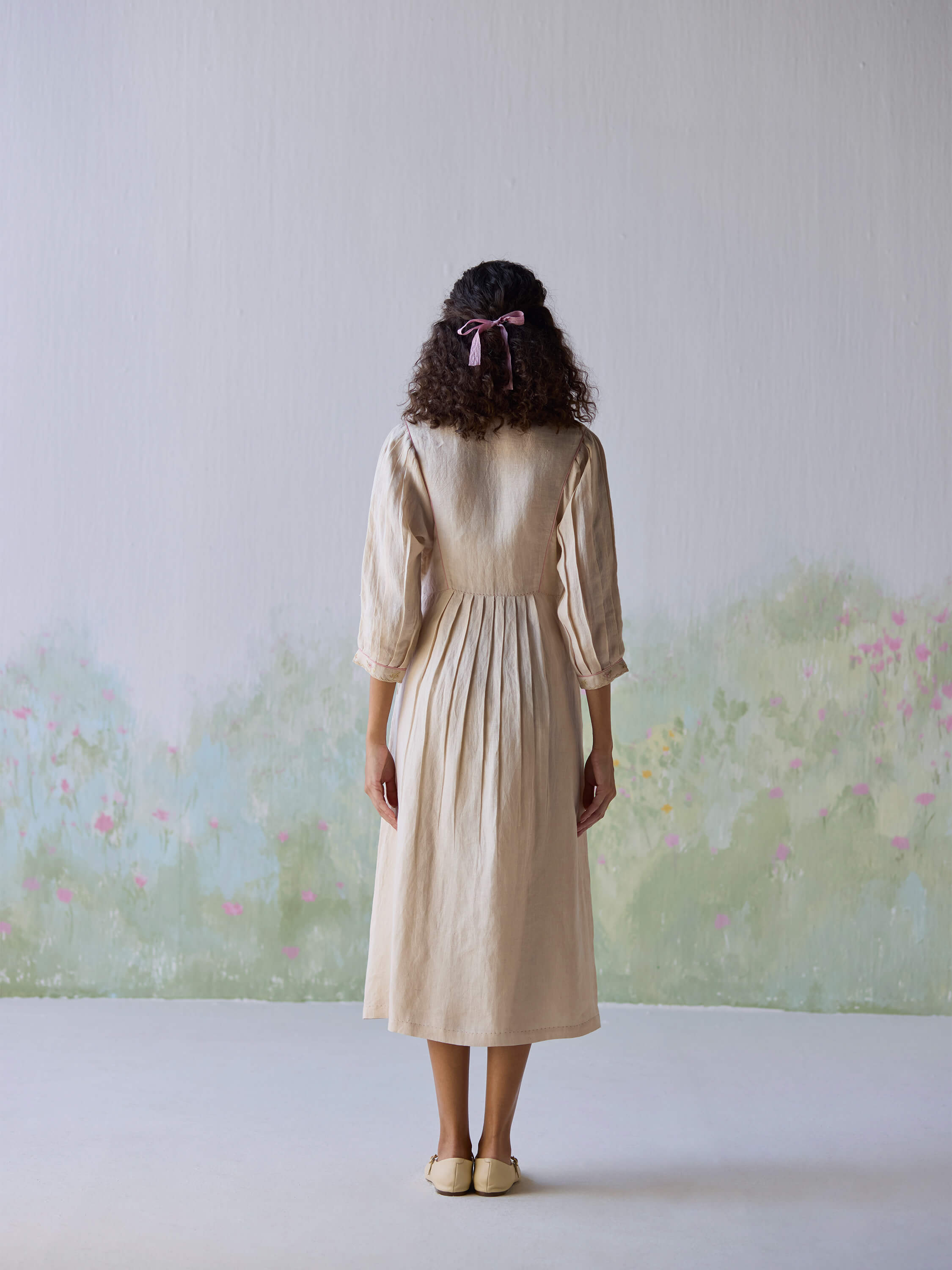 Back view of a model in a beige linen dress.