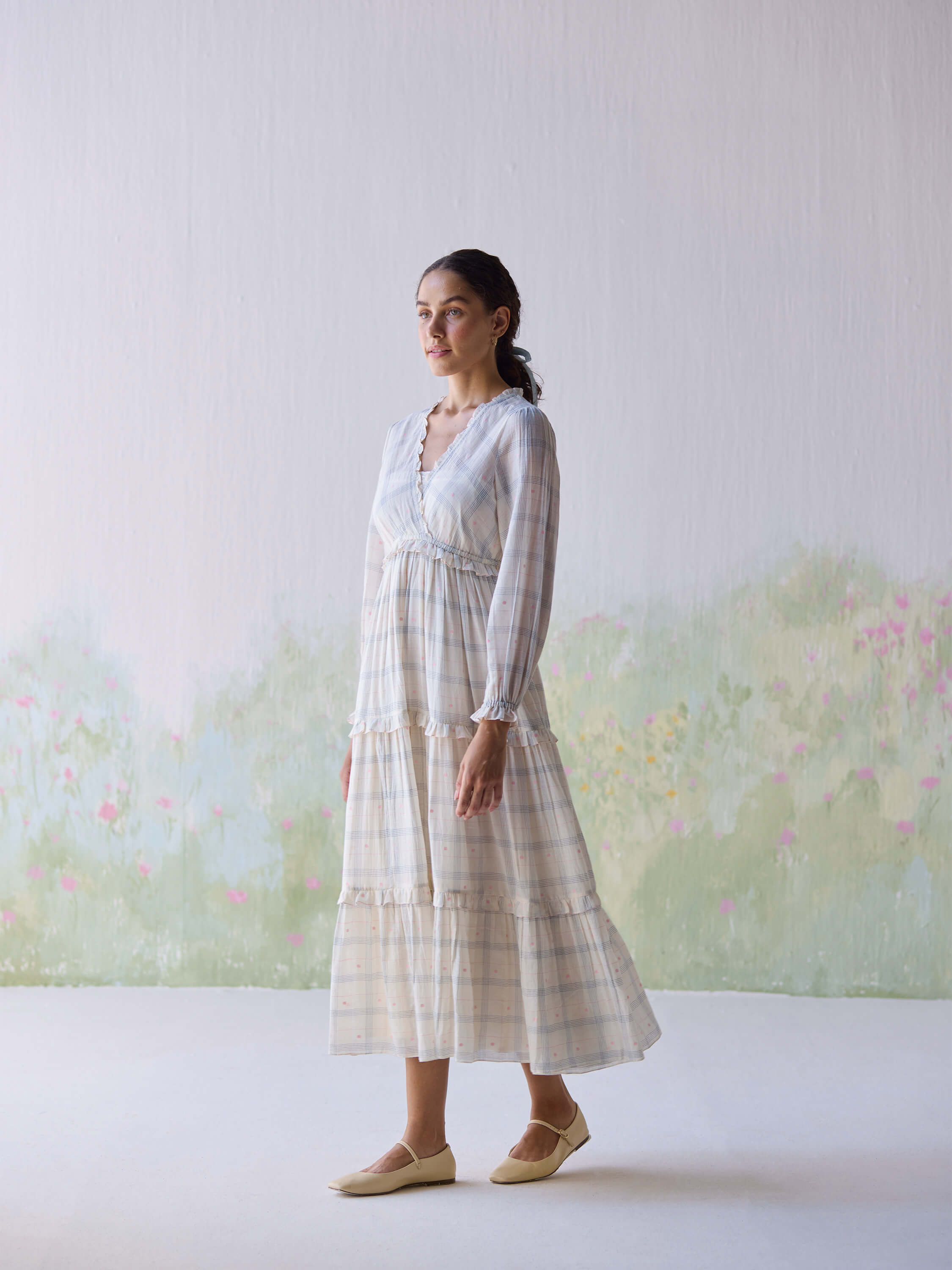 Model wearing the Paperdots Wrap Dress in a floral backdrop.