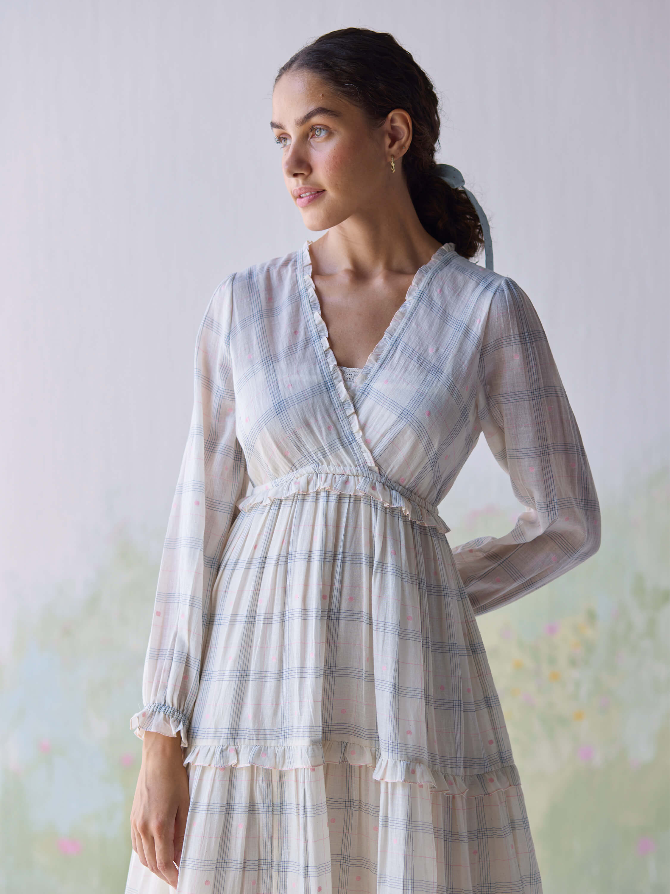 Elegant woman modeling Paperdots Wrap Dress in soft pastel plaid.