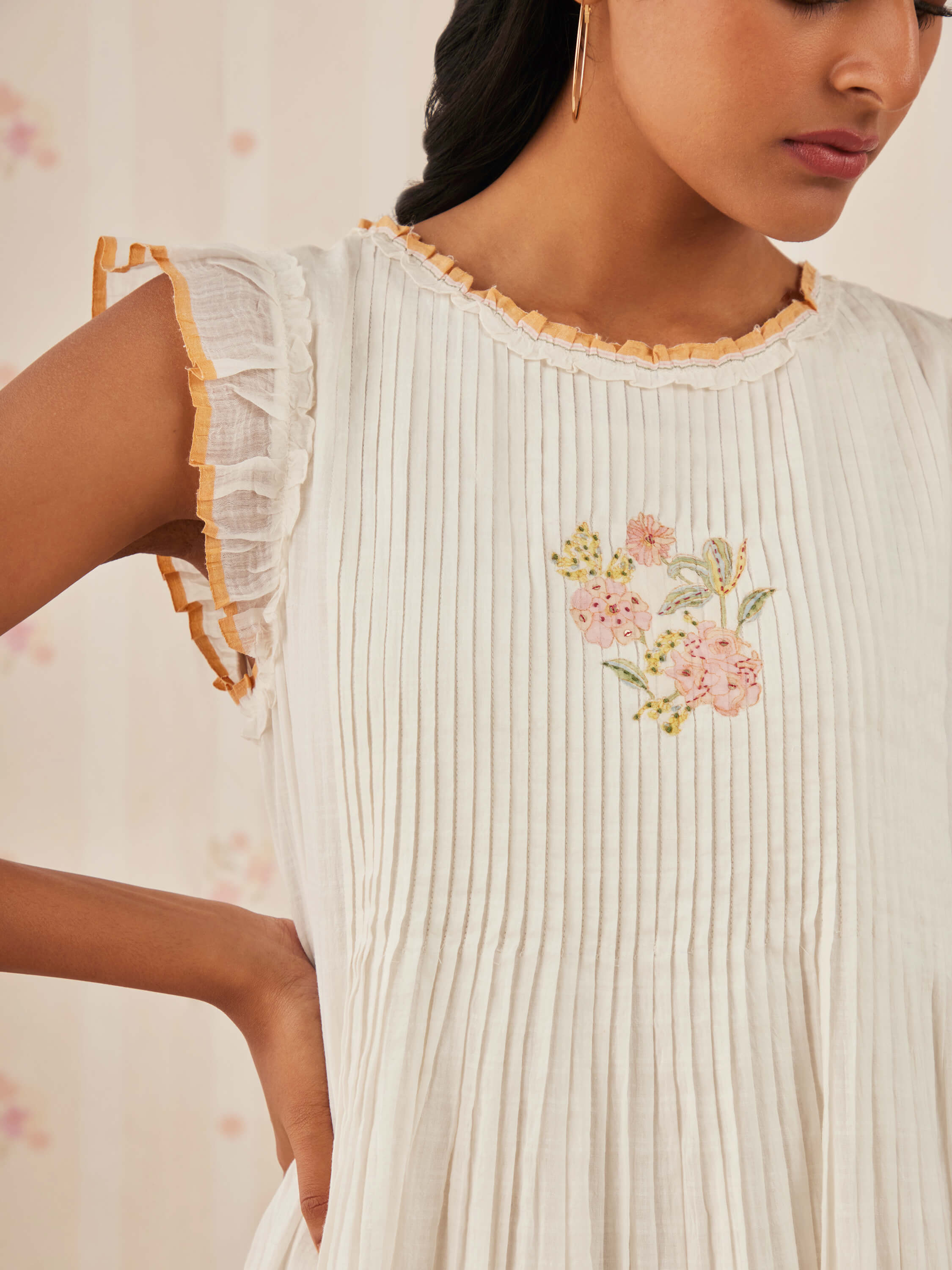 White embroidered dress with pleats and ruffled sleeves