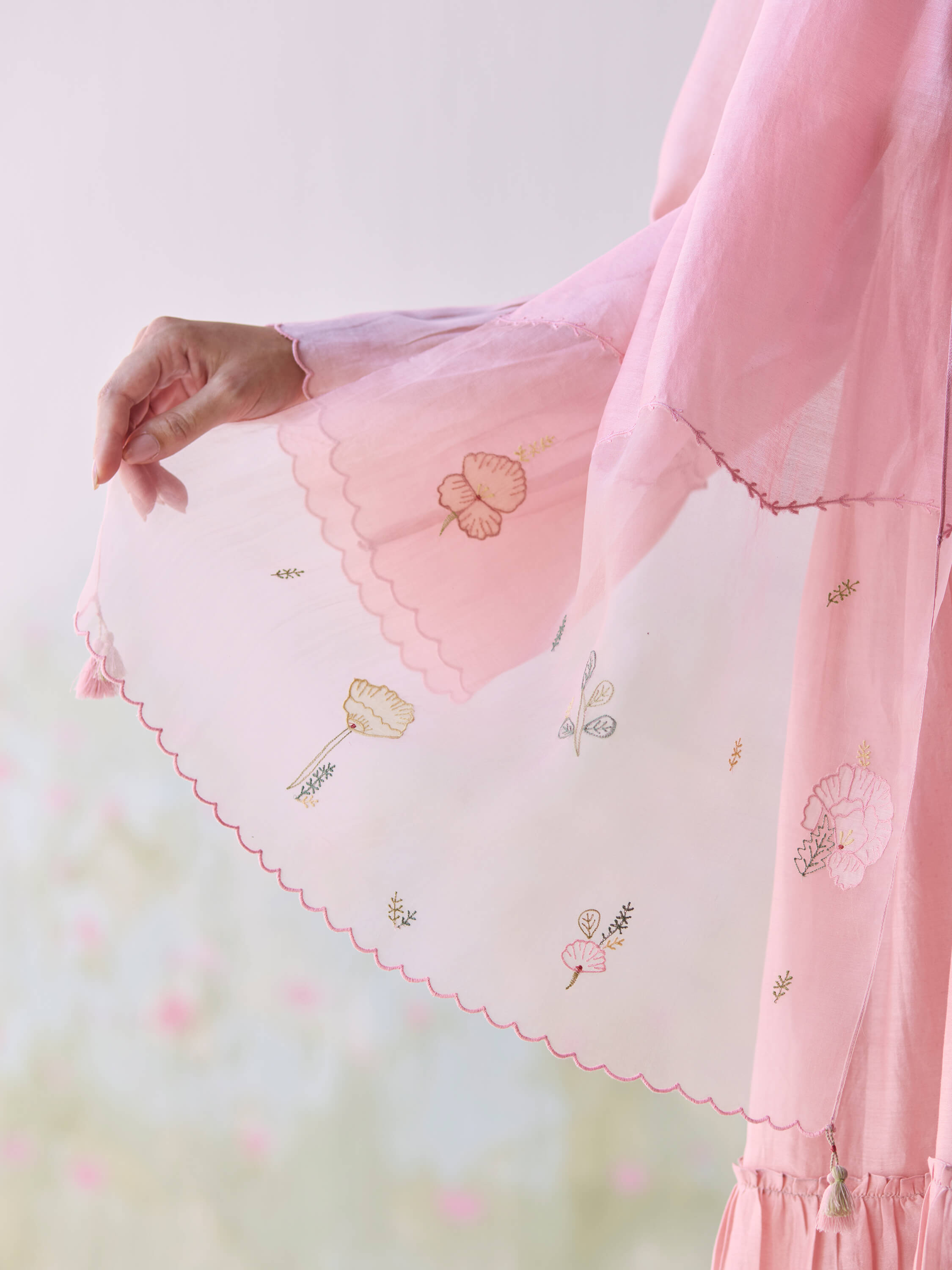 Close-up of pink chiffon sleeve with delicate floral embroidery.