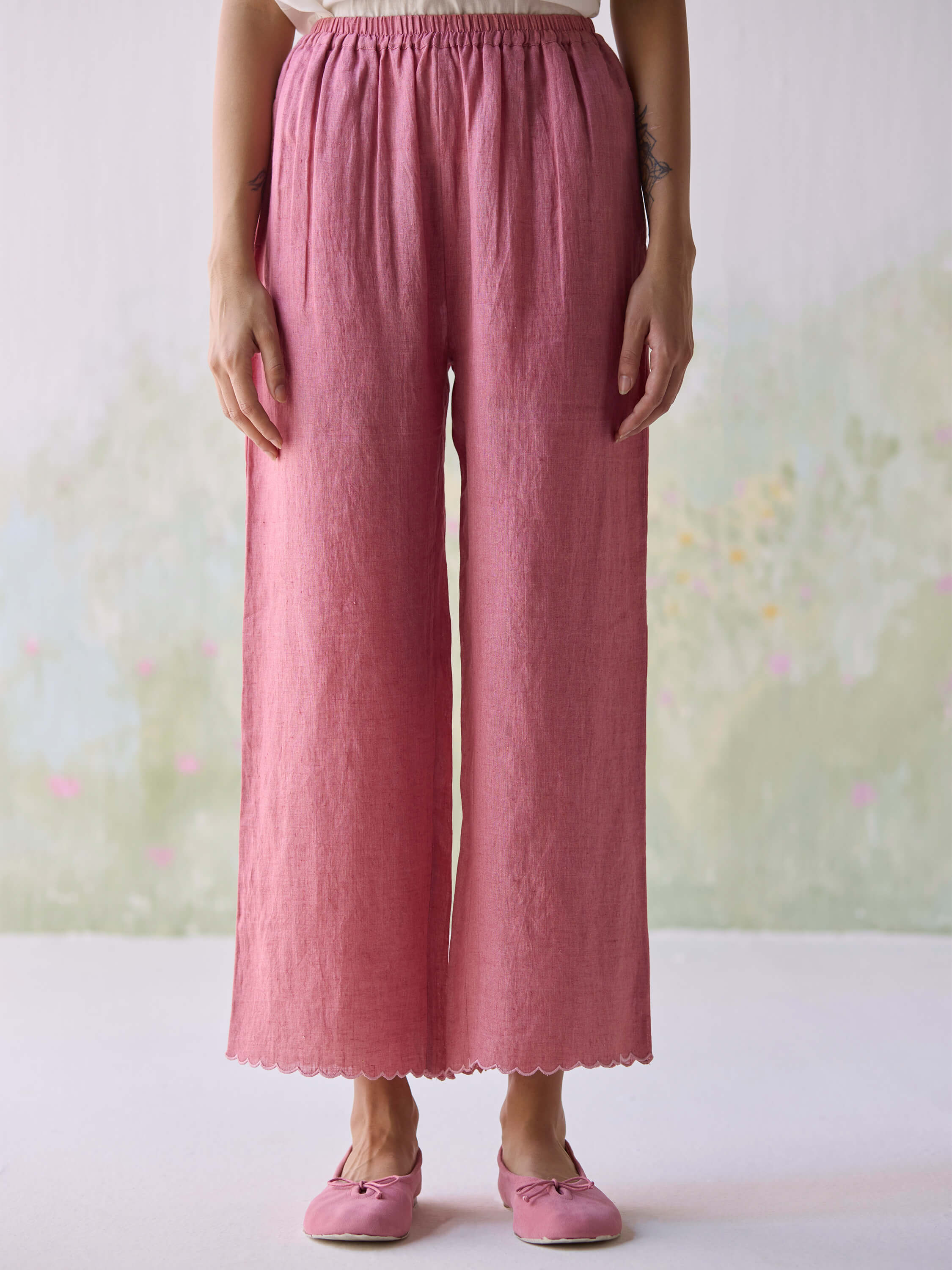 Woman wearing pink wide-leg pants and matching shoes.
