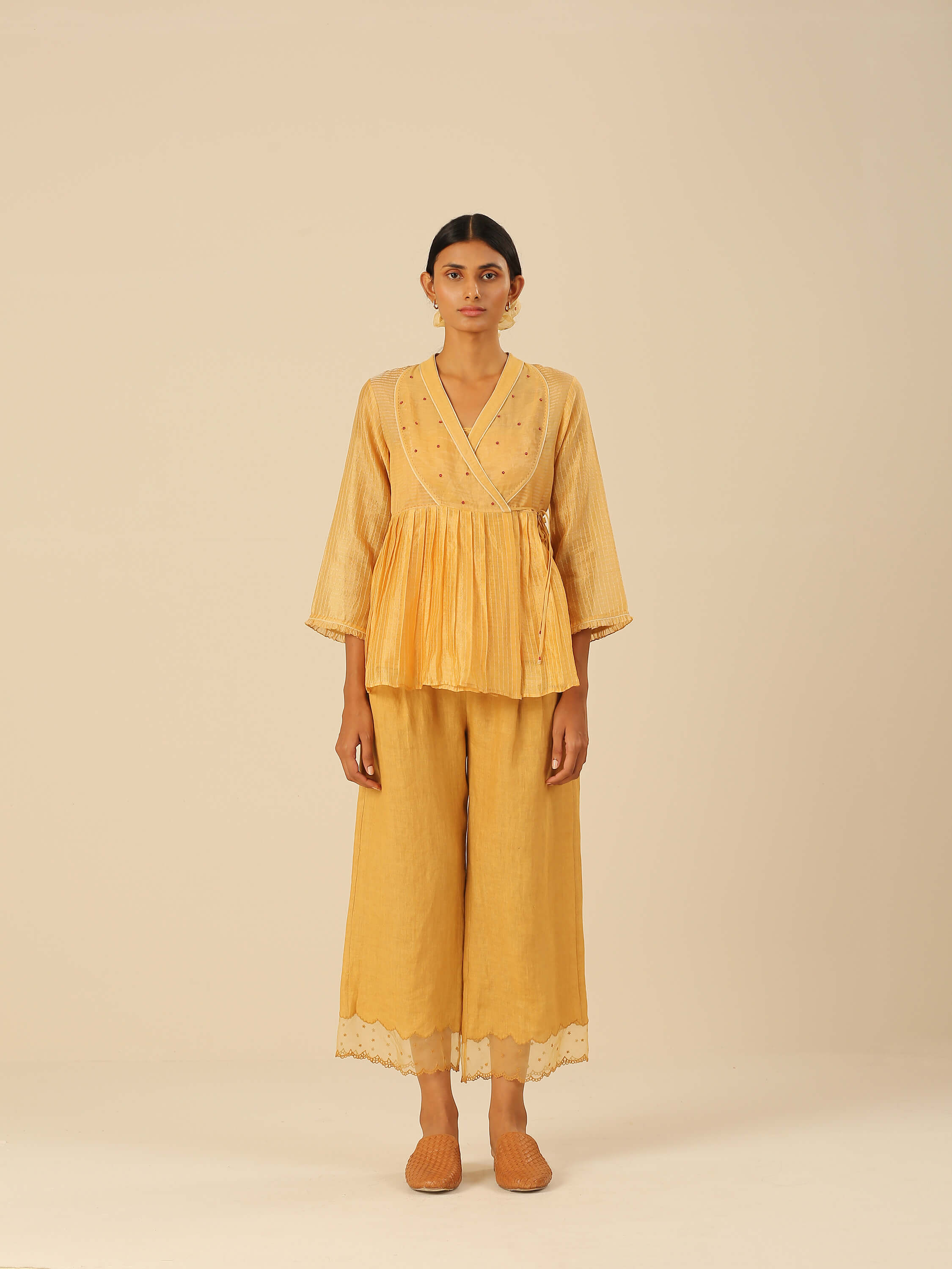 Woman wearing a stylish mustard yellow ensemble with embroidered top.