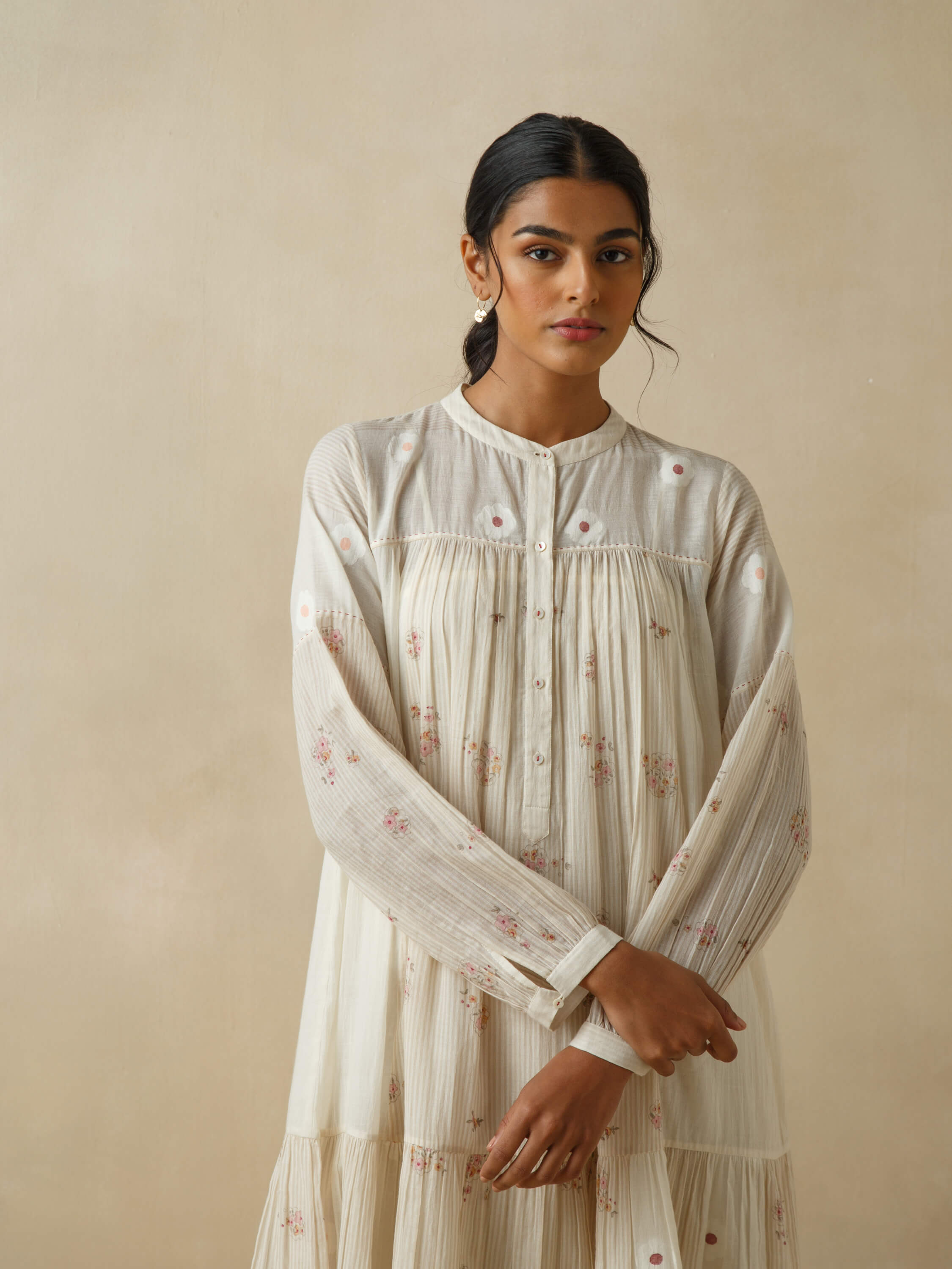 Woman wearing a floral embroidered A-line ivory dress.