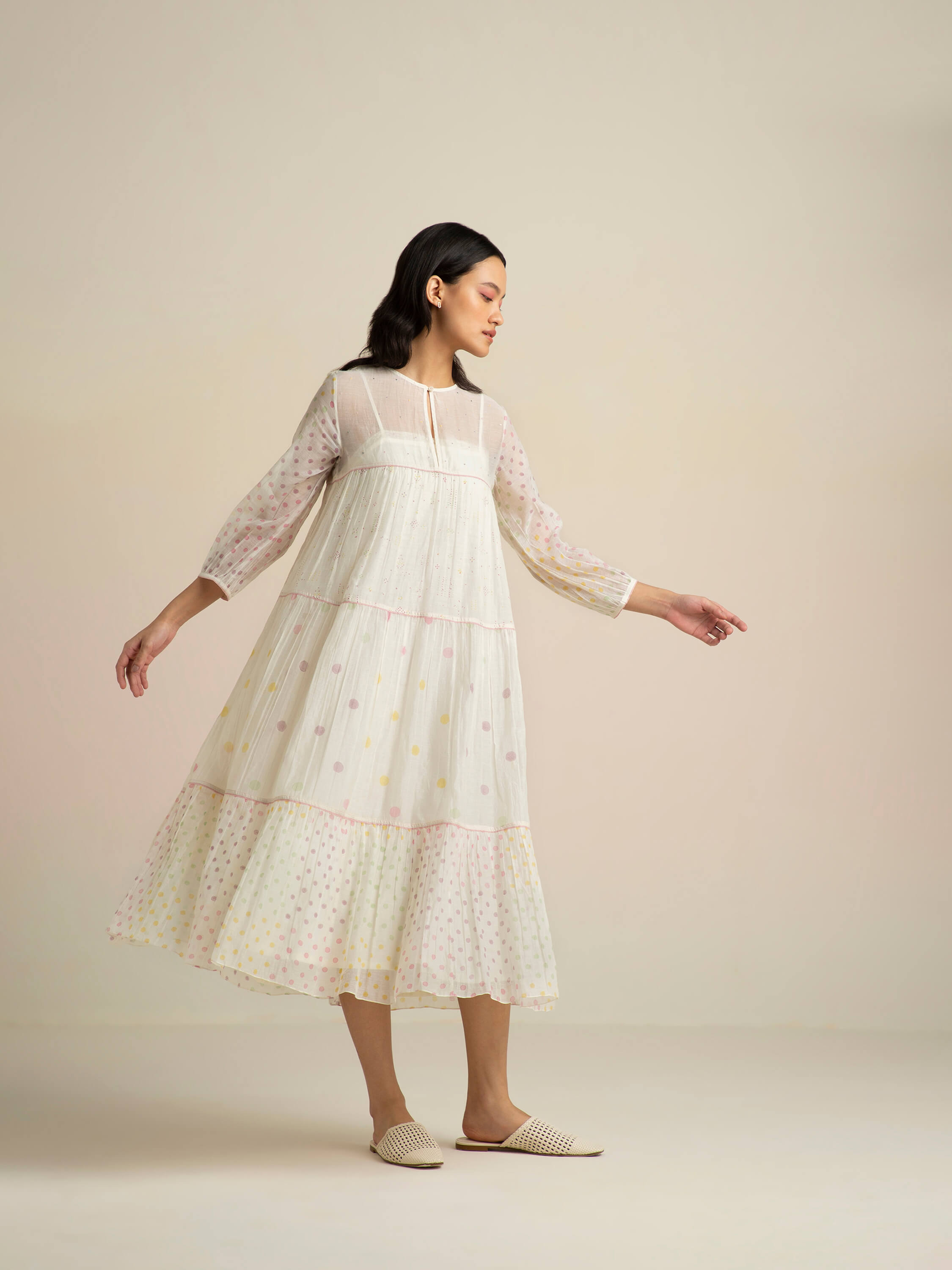 Woman in a sheer white polka dot midi dress.