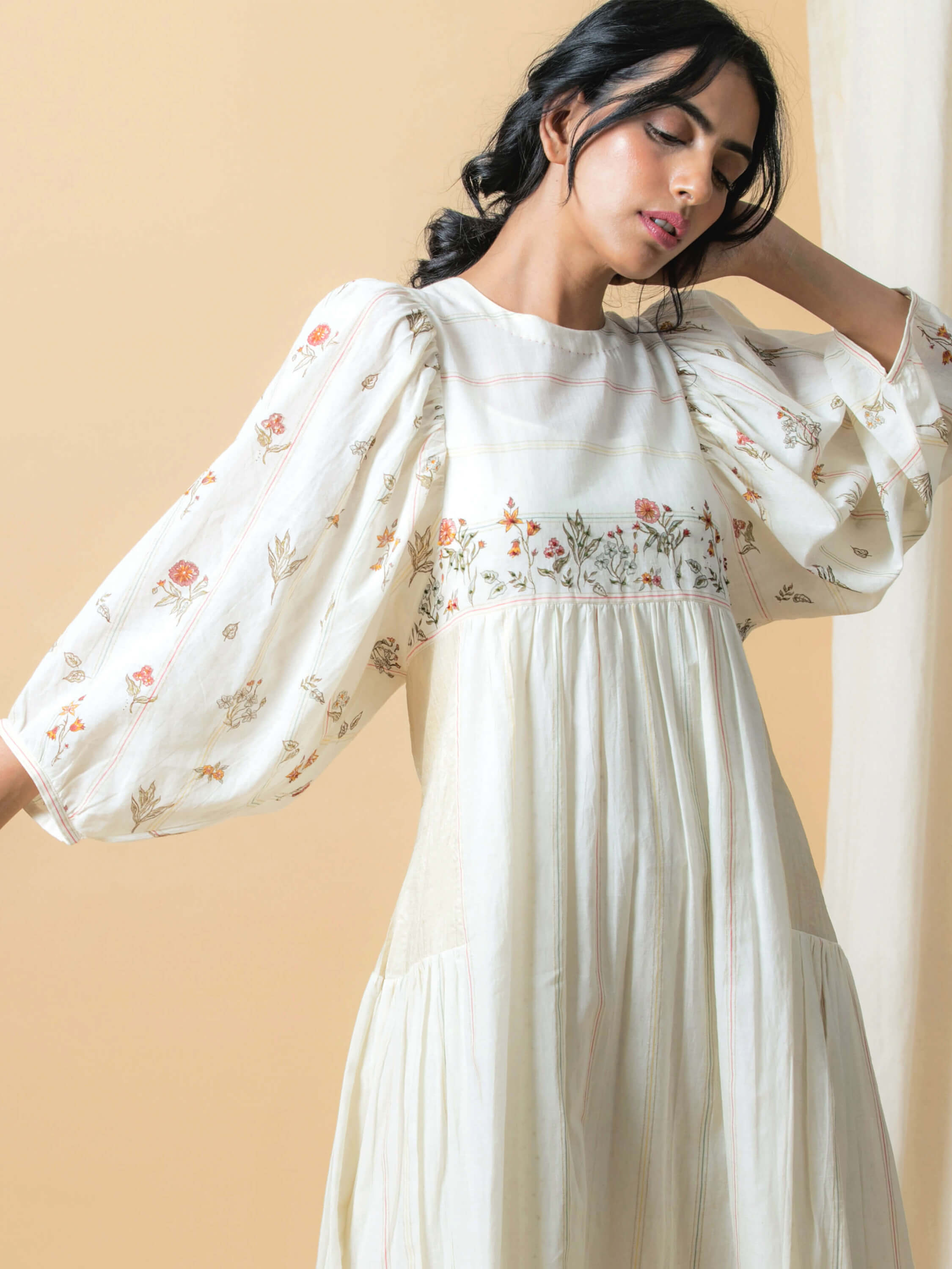 Woman wearing a white floral embroidered maxi dress.